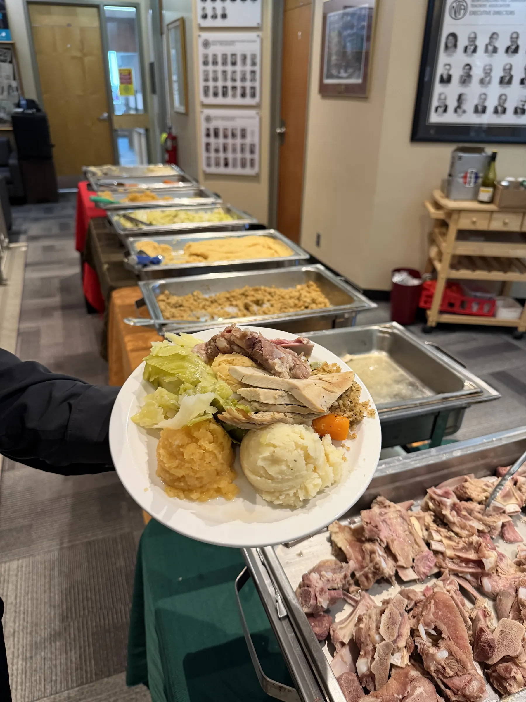 Plate of turkey and vegetables beside a Fireside Catering carvery and buffet trays