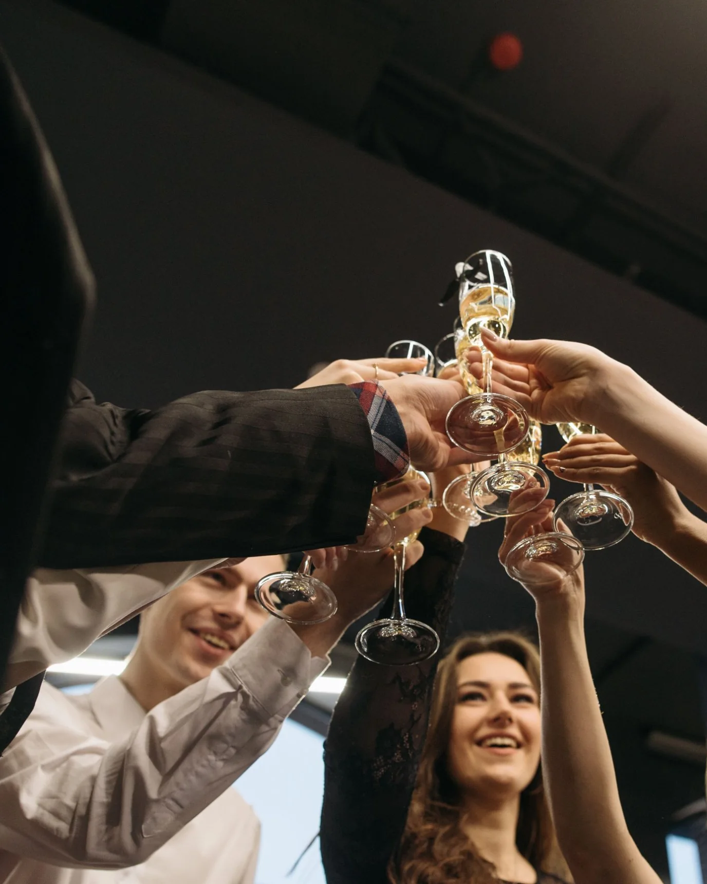 Guests raising champagne glasses together in a toast at a celebration